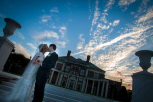 bride and groom kissing at sunset