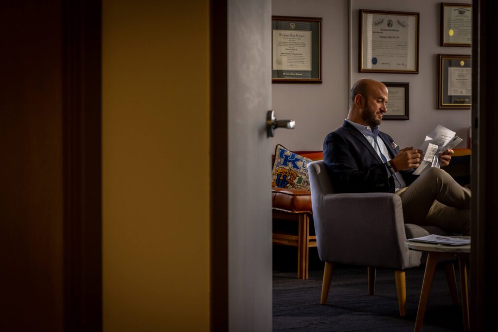 man reading a letter in a chair