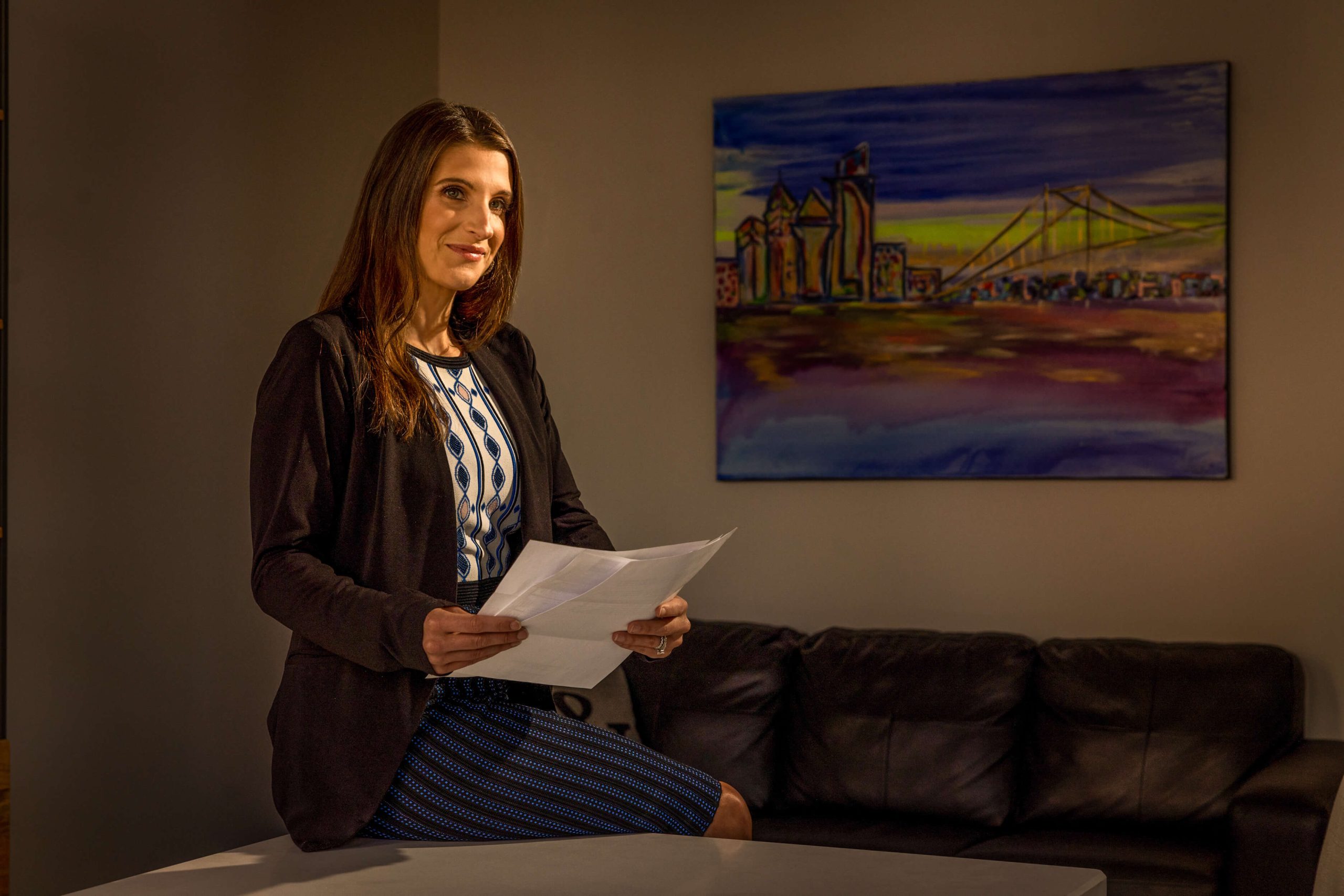 lawyer in reading book by window with philadelphia skyline