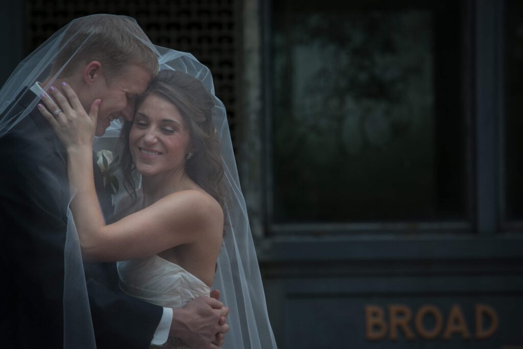 wedding couple hugging under the veil