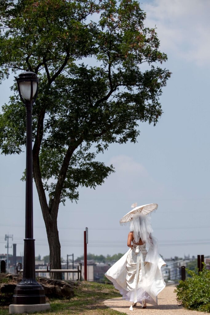 bride with umbrella walking on sidewalk