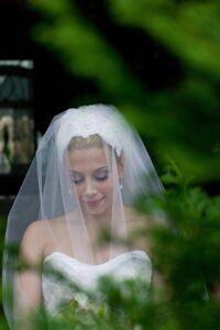 bride through a green tree leaves