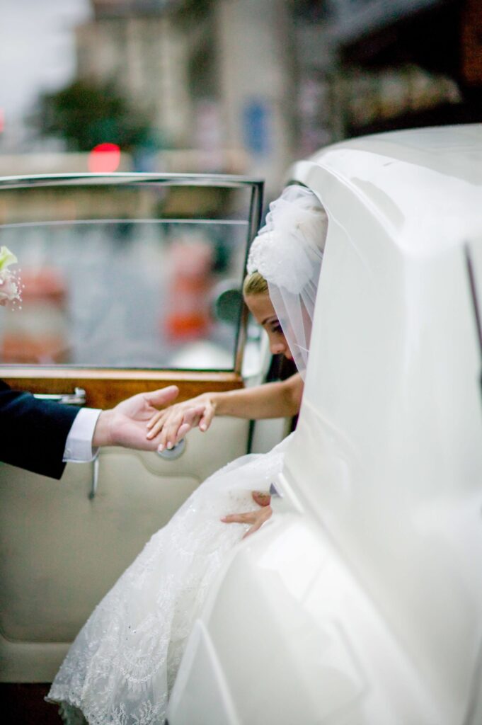 bride exiting a classic white car