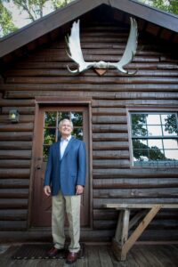 dick vermeil next to log cabin