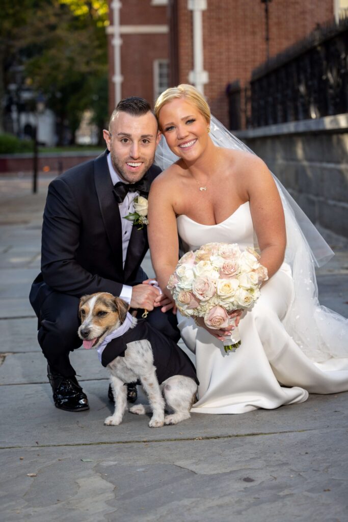 bride and groom posing with jack russell terrier dog