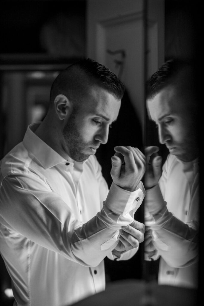 groom adjusting cufflinks on wedding day
