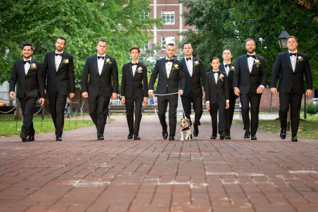 groomsmen in tuxedos walking in philadelphia with dog