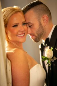 groom leans head into bride