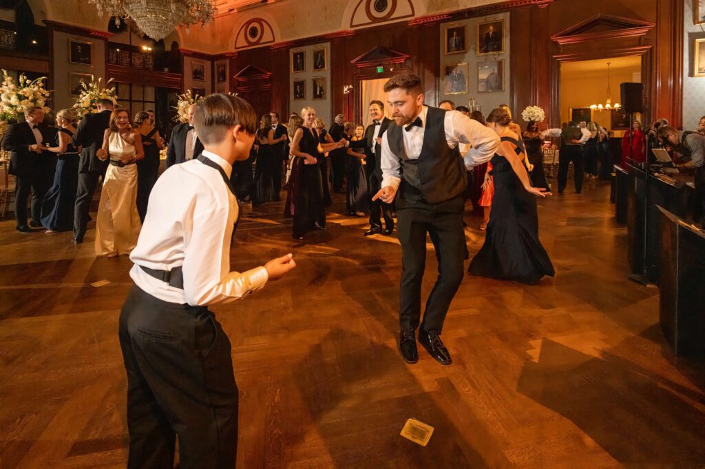 man and boy dance together at wedding reception