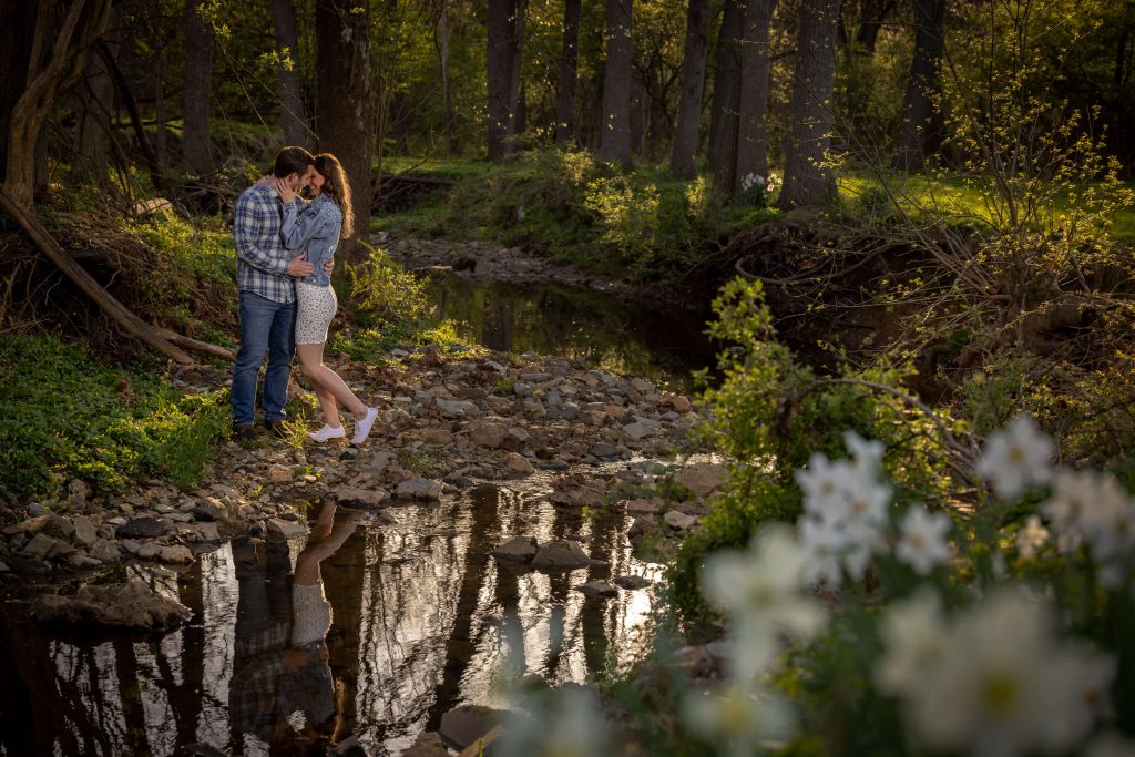 man and woman embracing by water creek