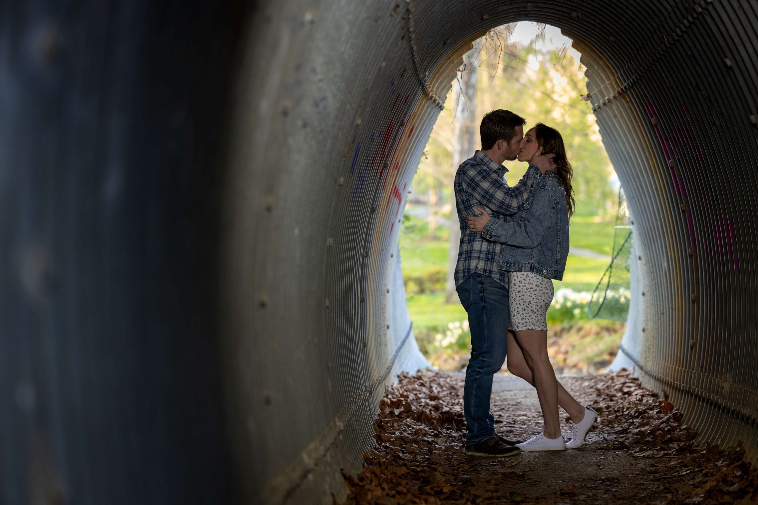 man and women kissing inside of metal tunnel