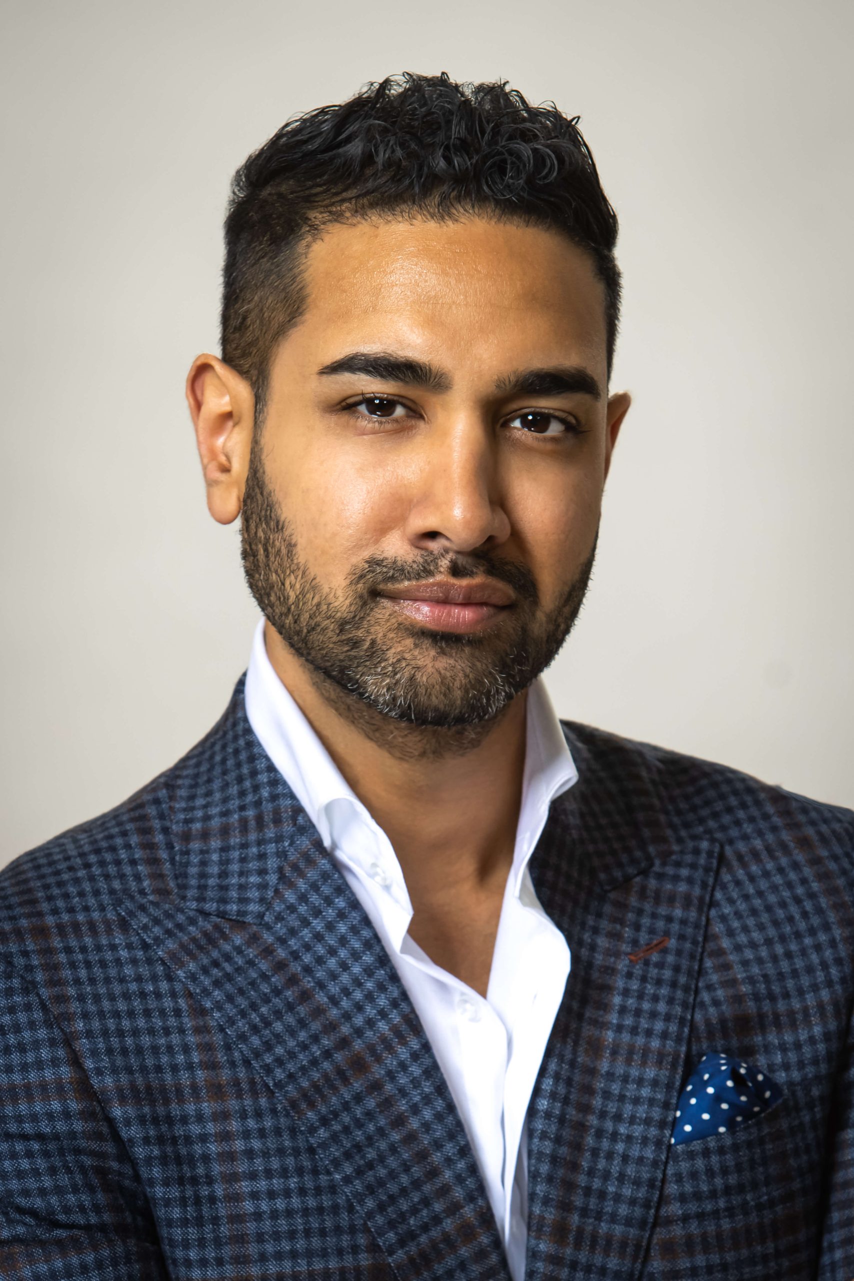 man in blue shirt and open collared shirt