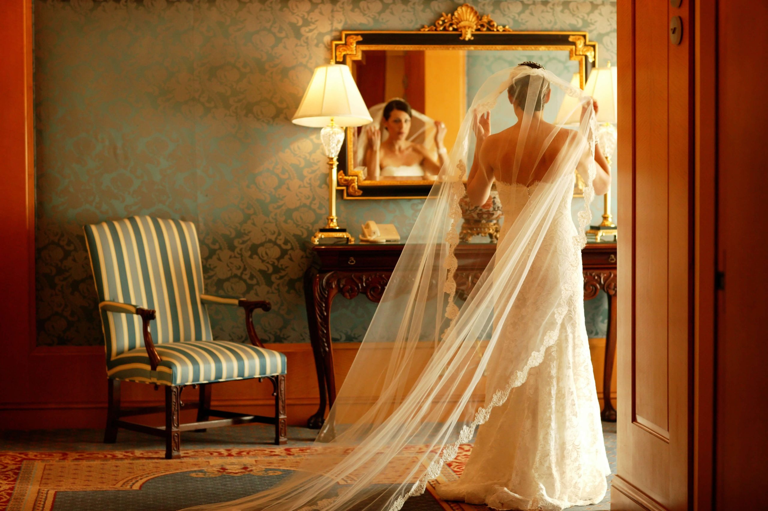 bride getting ready in hotel mirror