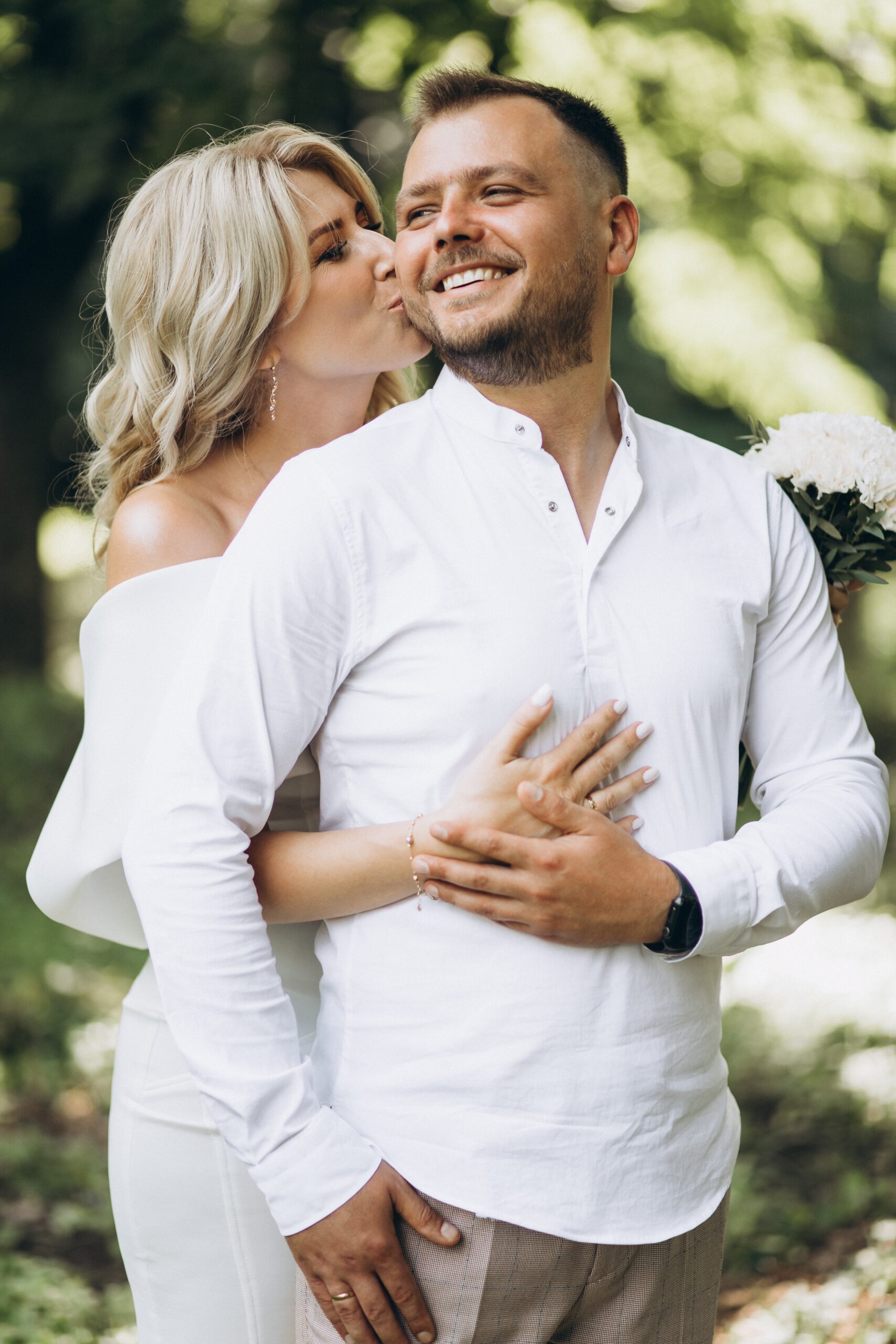 man and woman standing at rustic wood barn