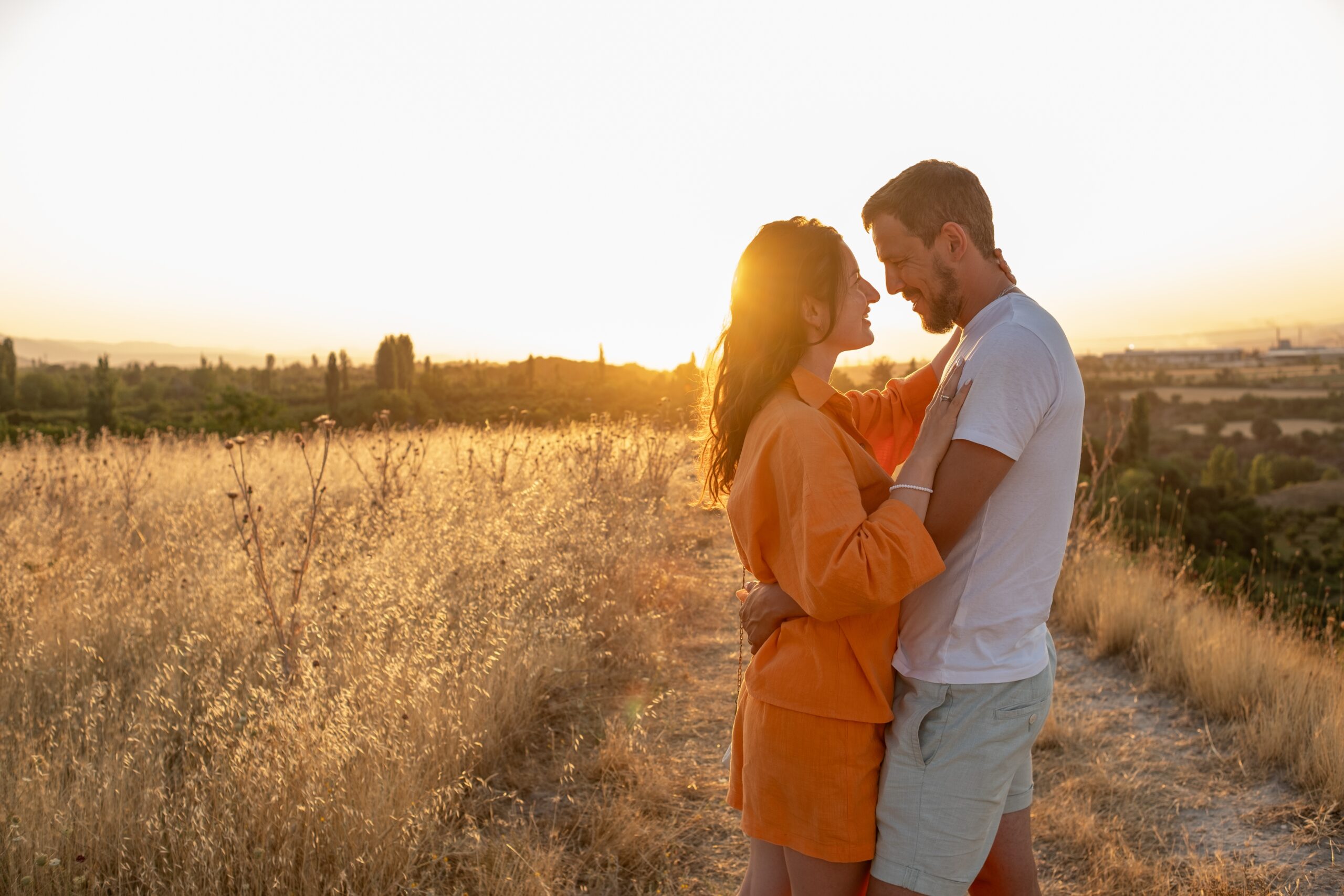 man holding and kissing woman in forest