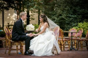 bride and groom holding hands at outdoor table