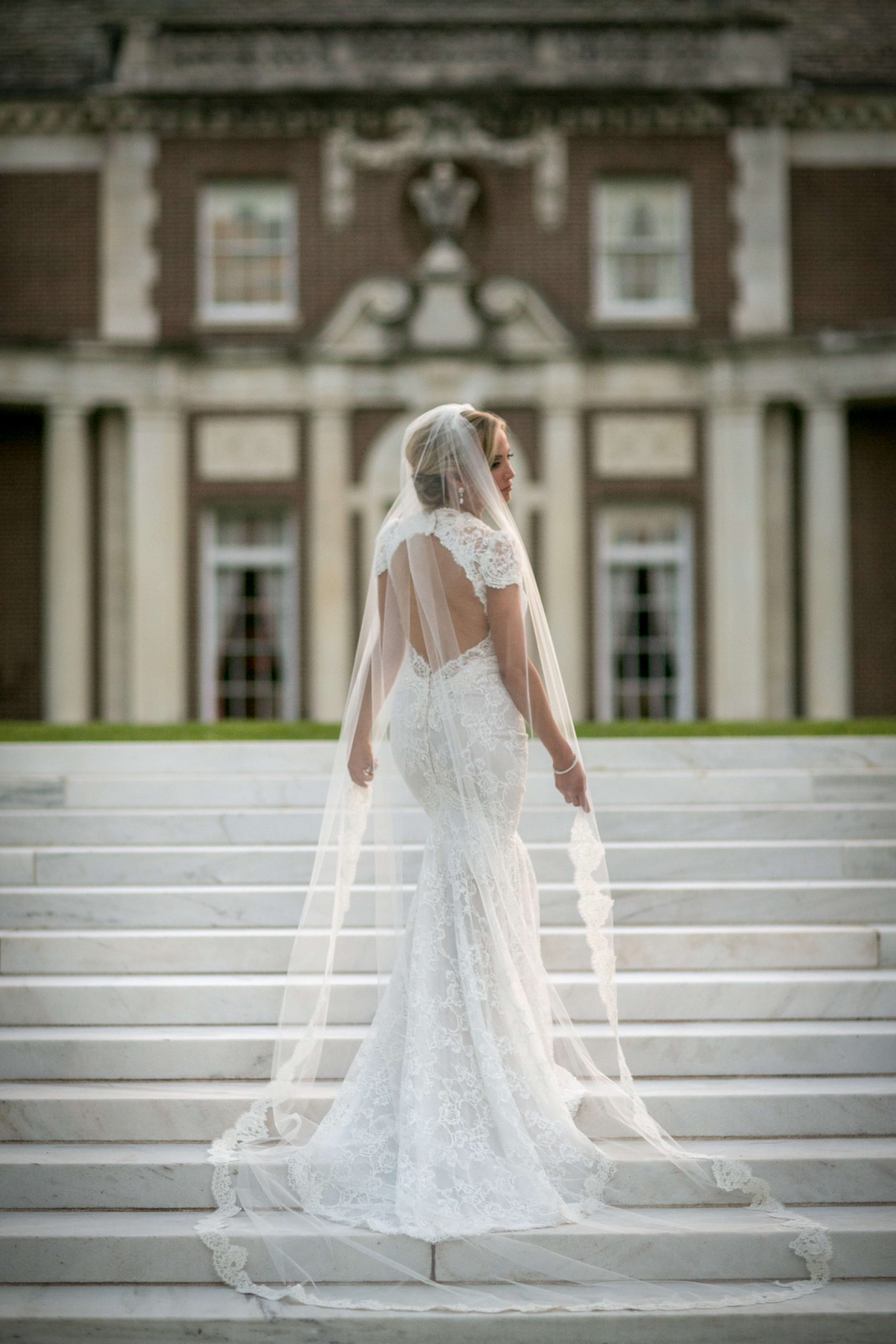 bride walking marble stairs at luxury mansion
