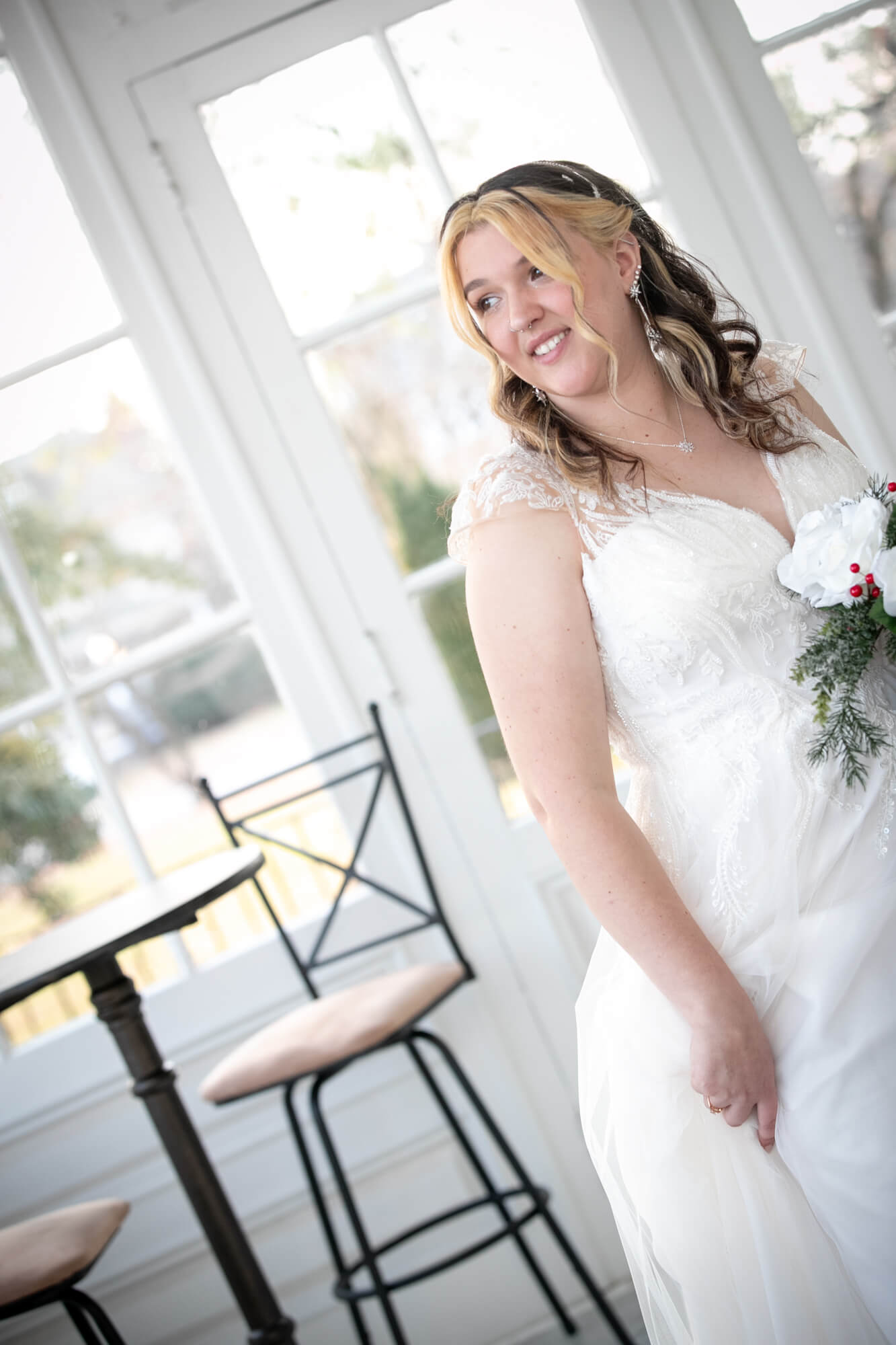 bride in white sunroom with bouquet of flowers