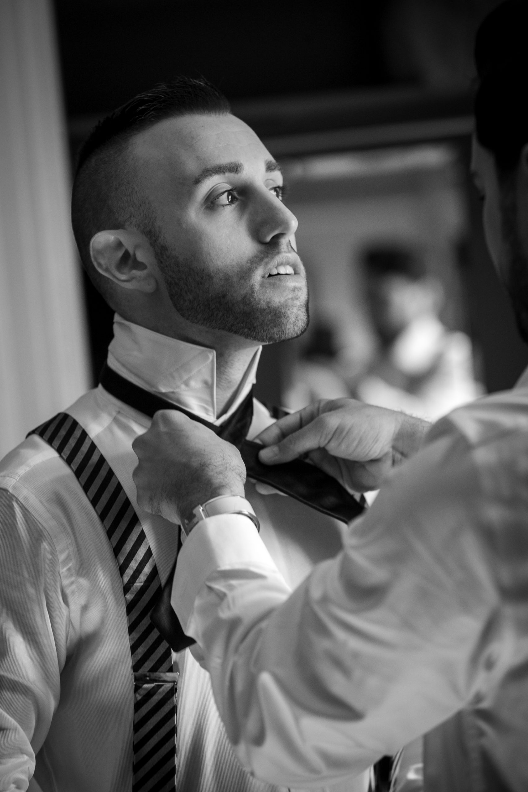 groom and groomsmen tie bowties in the mirror