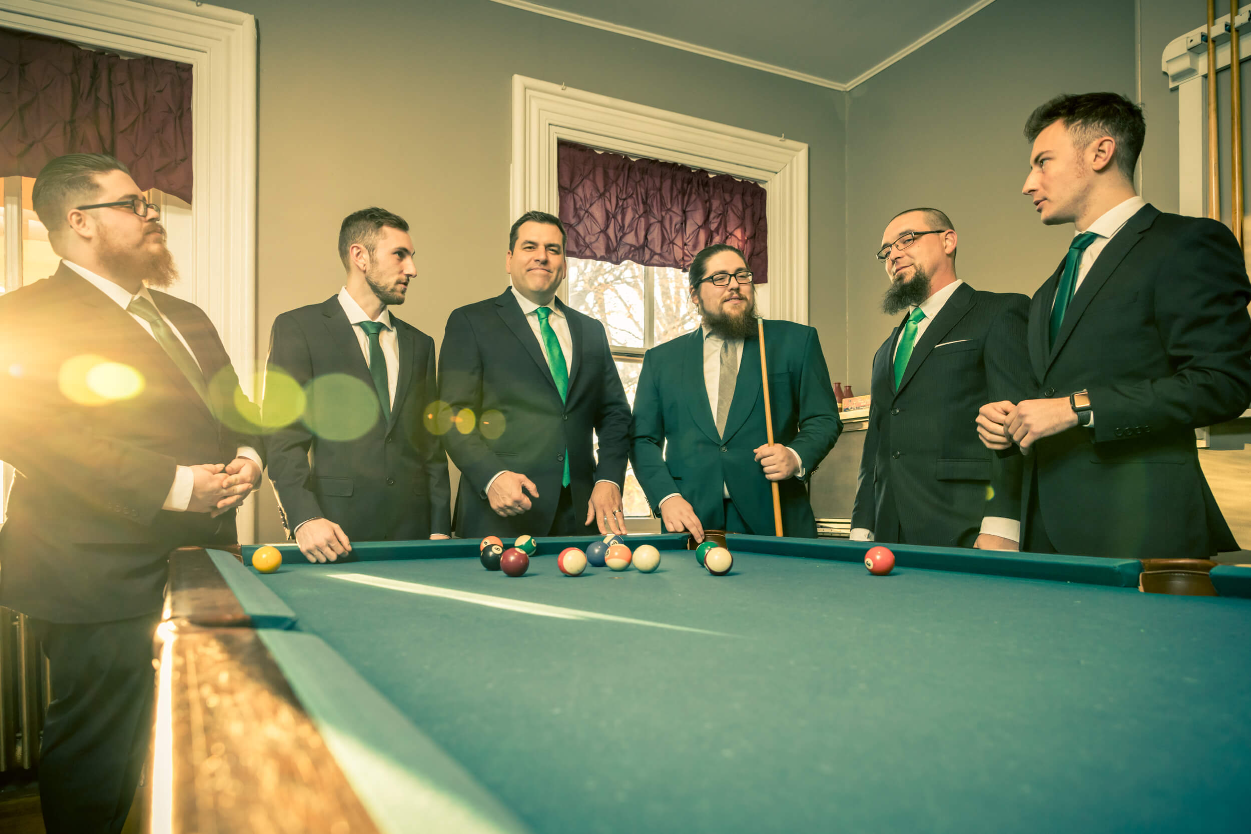 groomsmen in suits at pool table