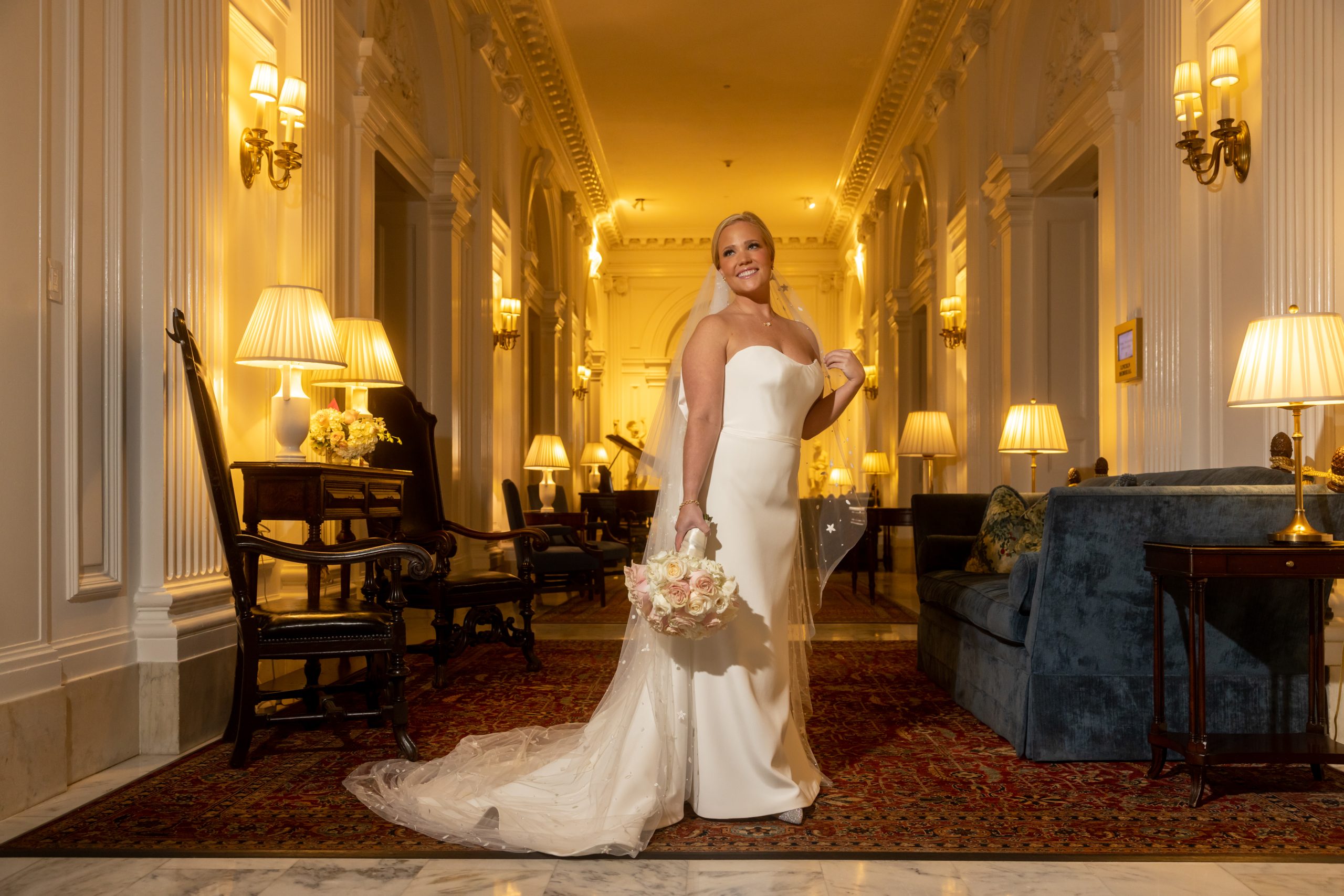bride posing in an elegant hallway with flowers