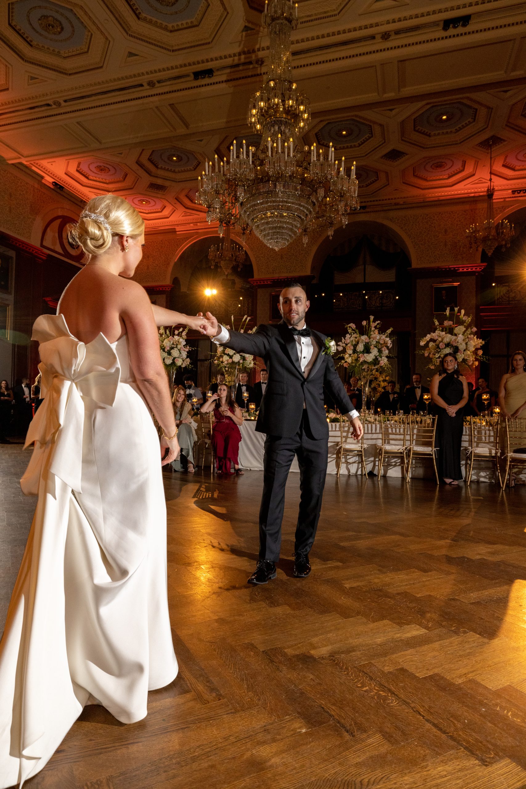 bride and groom share a first dance in grand ballroom