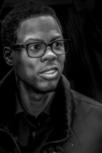 chris rock wearing black glasses and coat