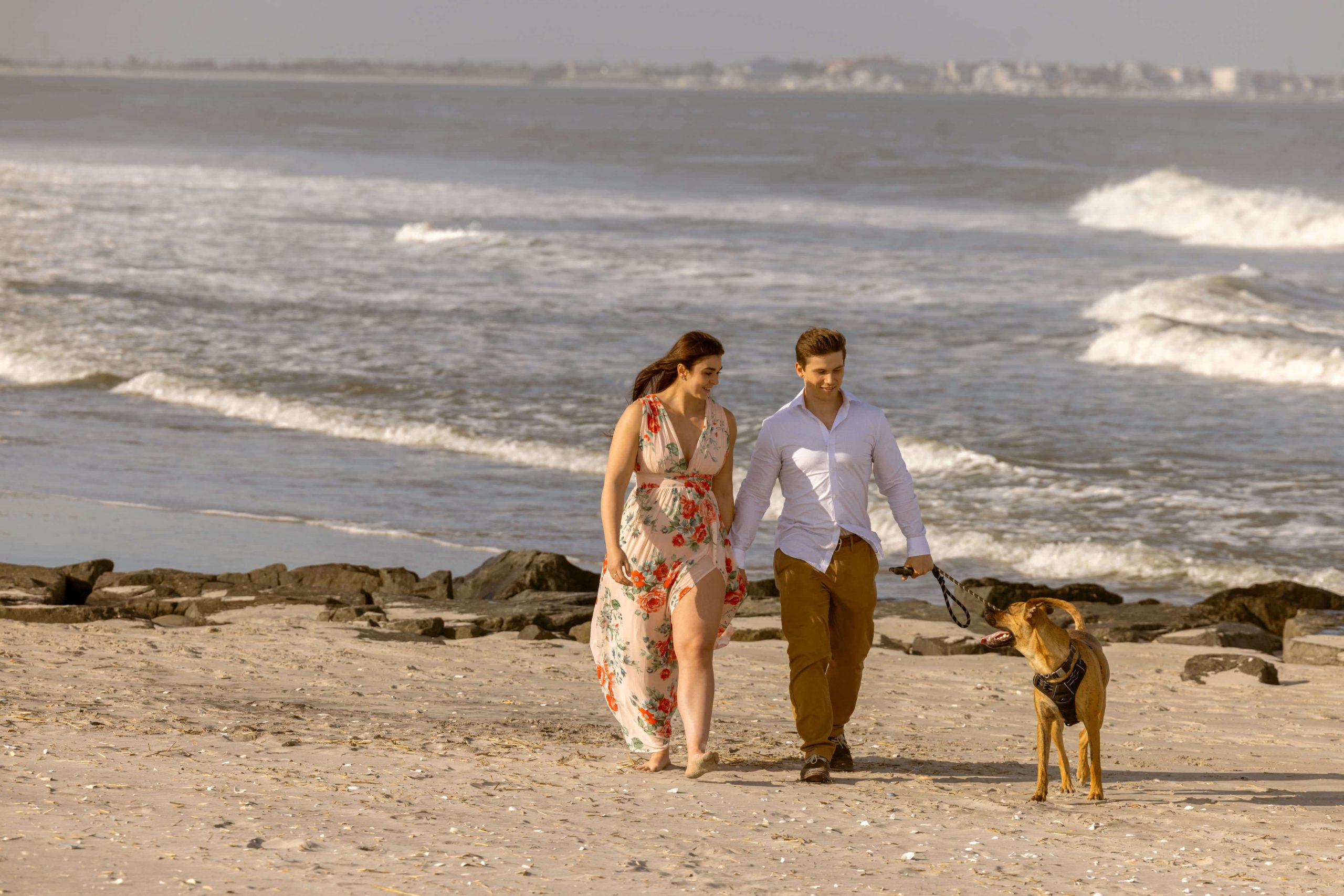 couple walking dog on the beach in New Jersey