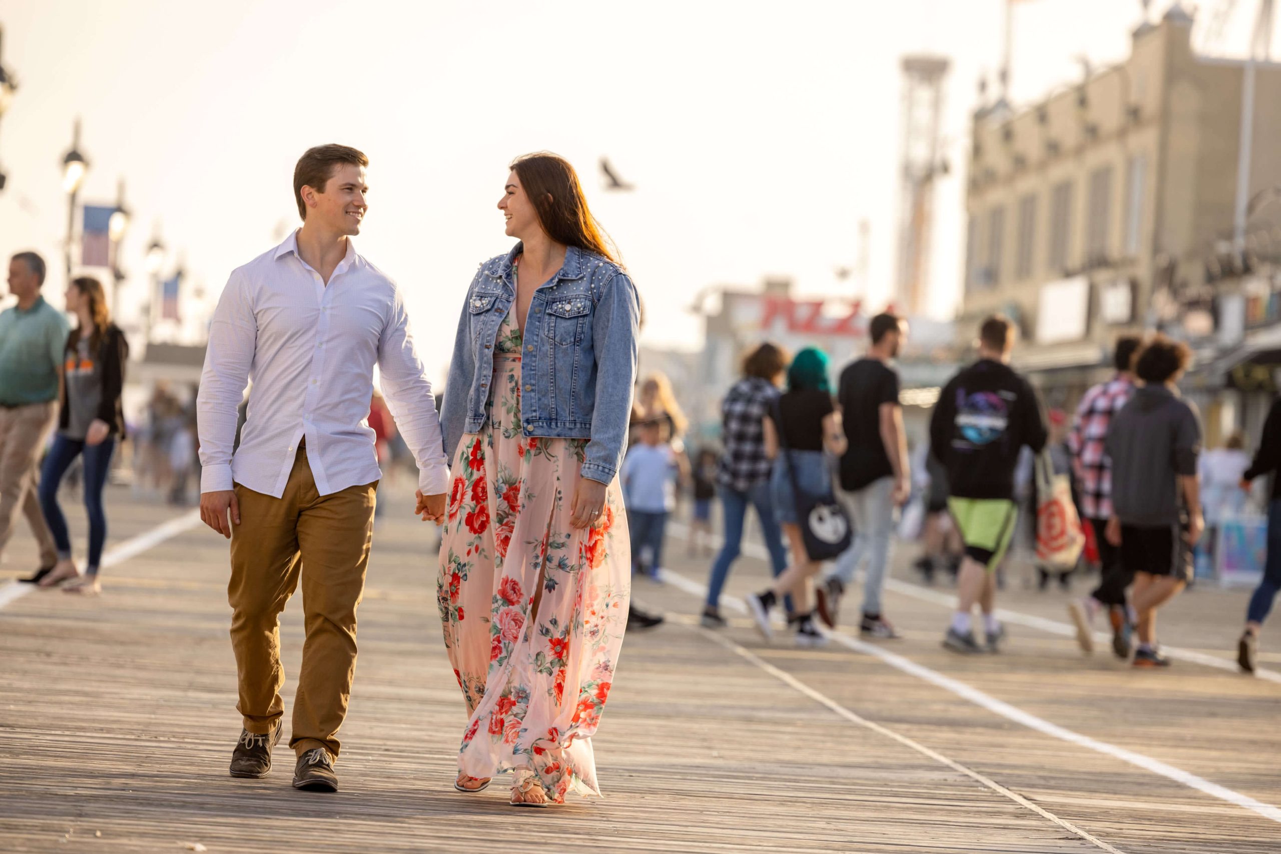 couple holding hands at boardwalk in Ocean City
