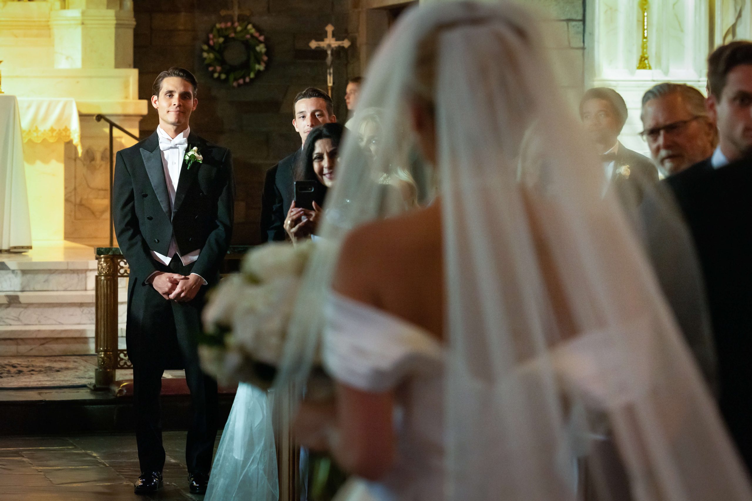 grooms sees bride walk down the aisle in wedding dress