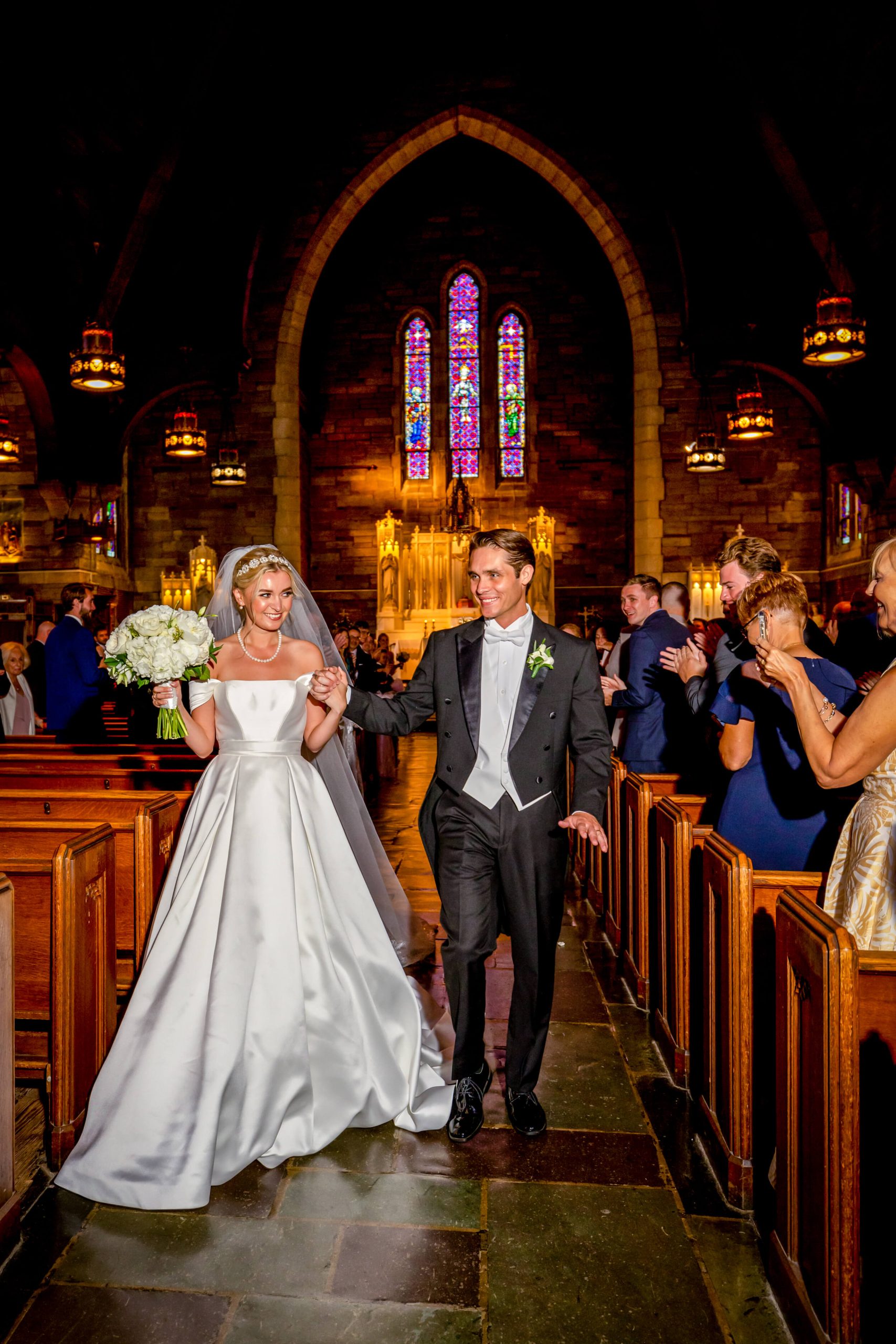bride and groom walk down aisle in catholic church