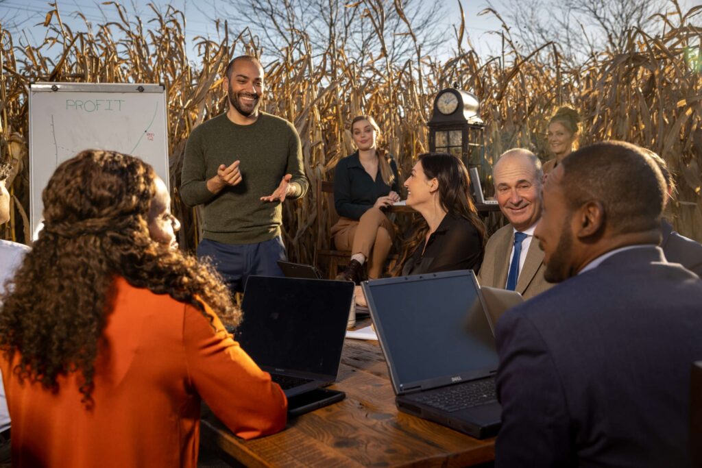 group of men and women talking at business meeting in cornfield