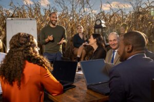 group of men and women talking at business meeting in cornfield