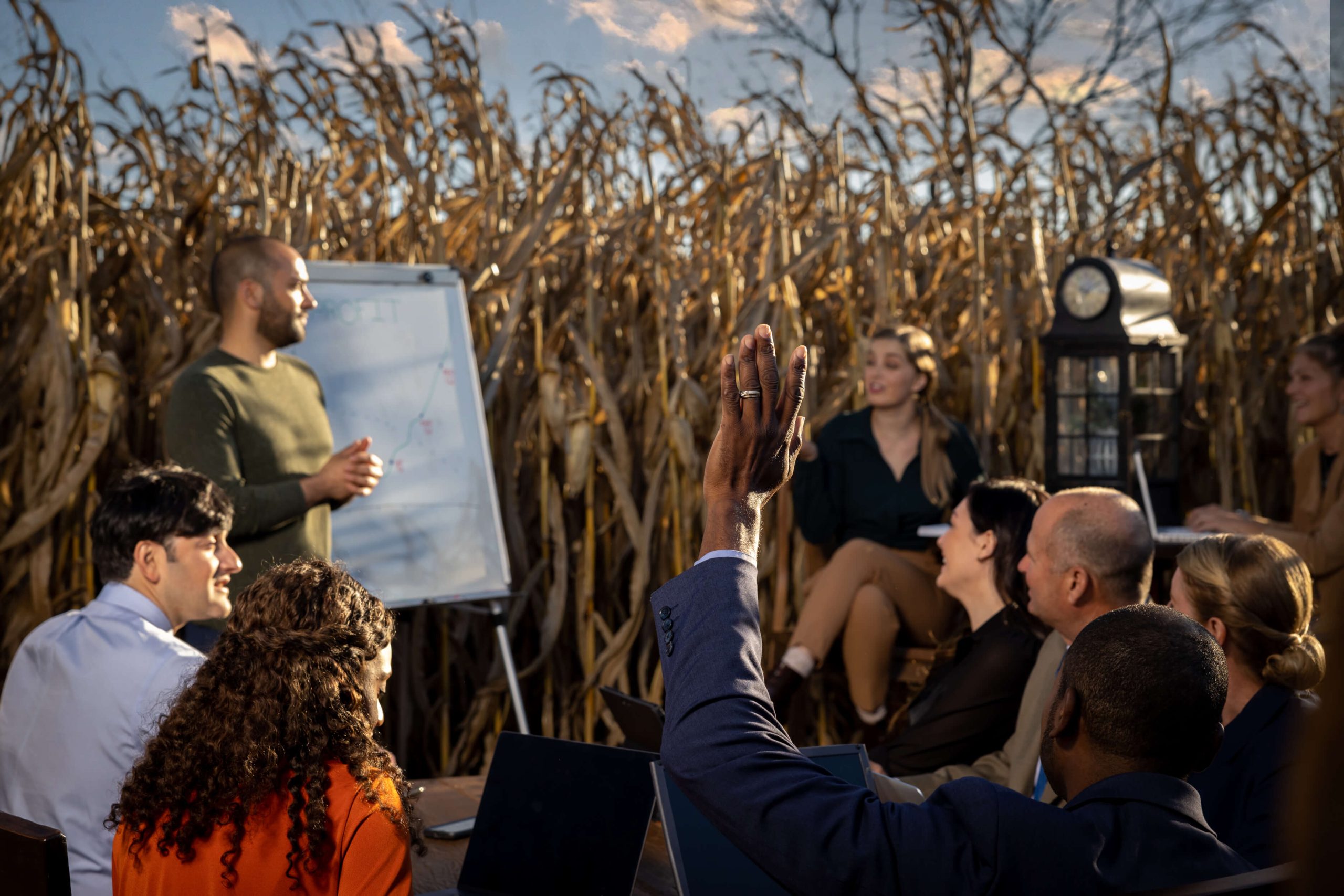 raising a hand during group conversation in a cornfield