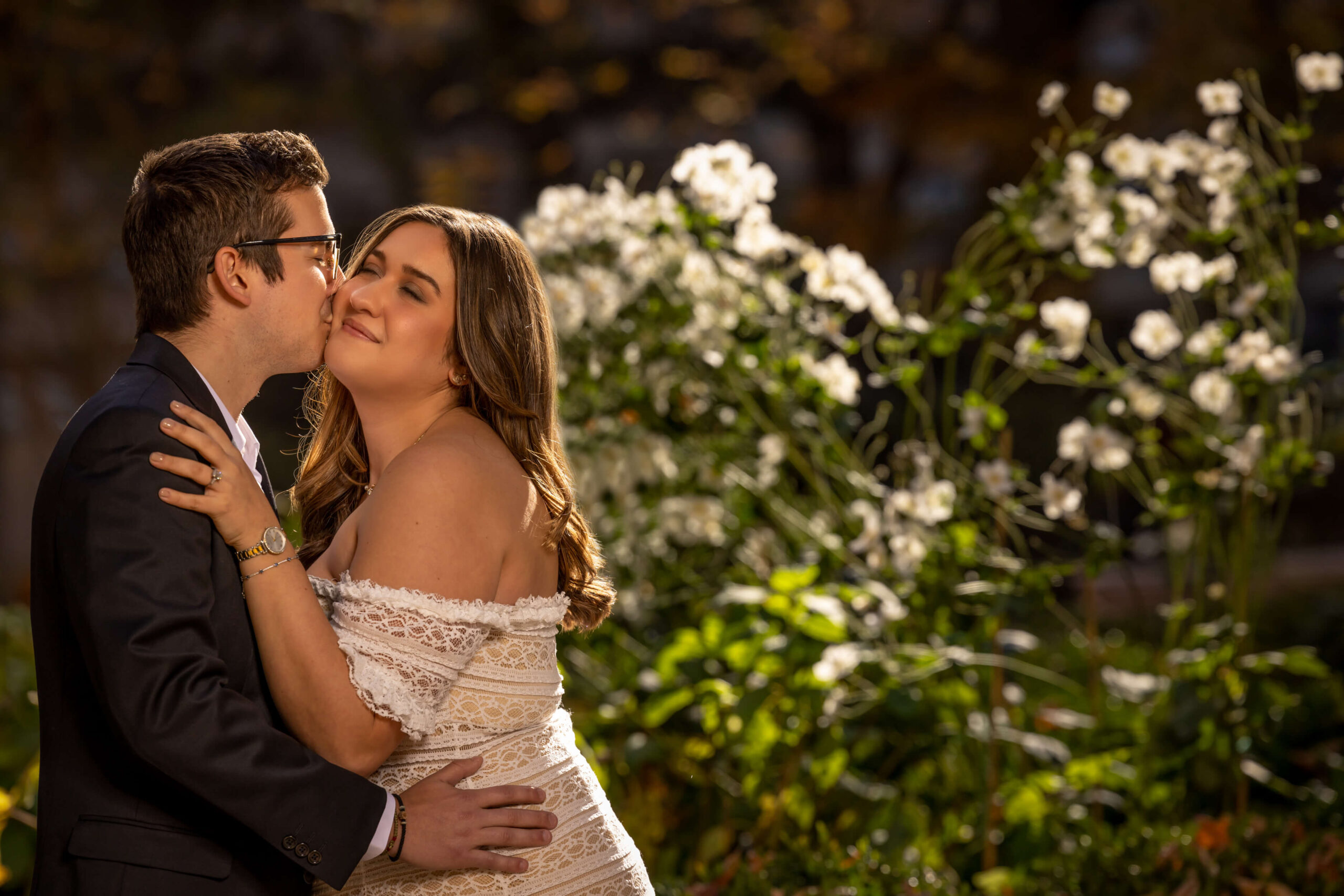 couple kissing by white flowers in rittenhouse square