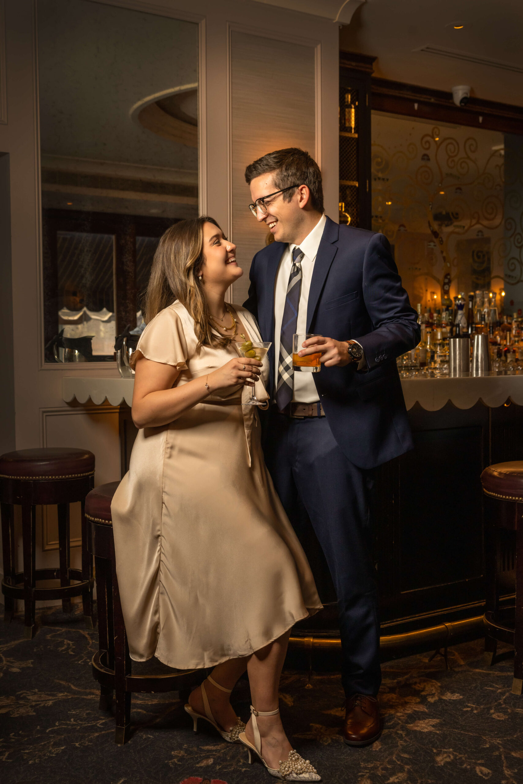 man and woman flirting at bar and sharing cocktails