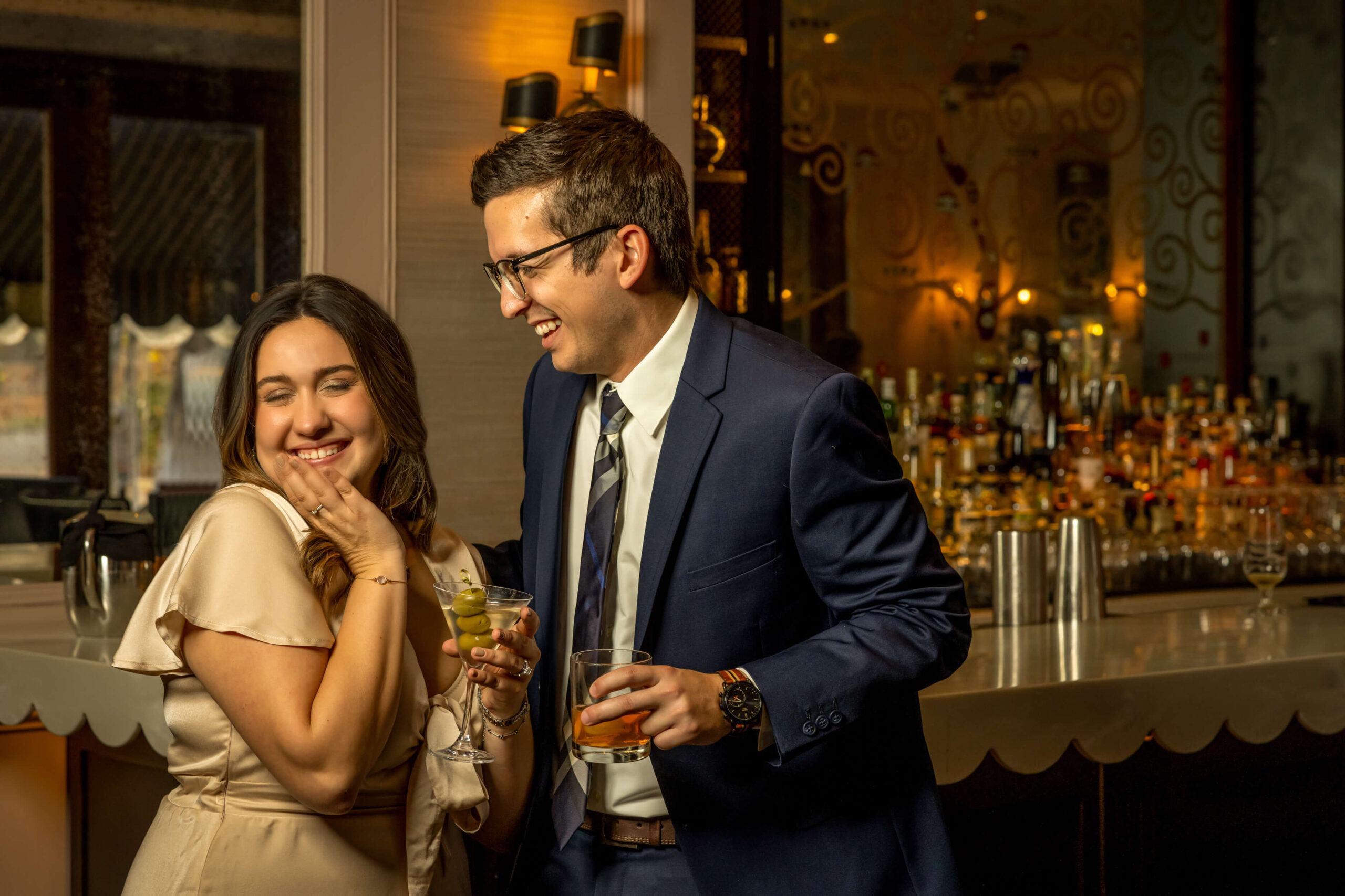 man and woman flirting at bar and sharing cocktails