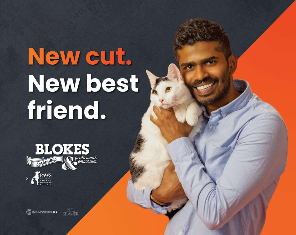 man in blue button down shirt smiling and holding a white cat