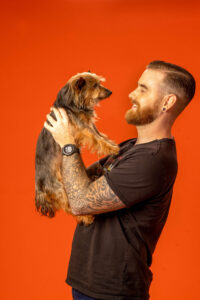 man holding and looking at dog