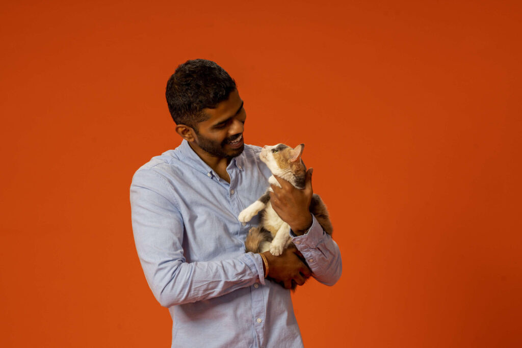 man smiling and holding a cute cat