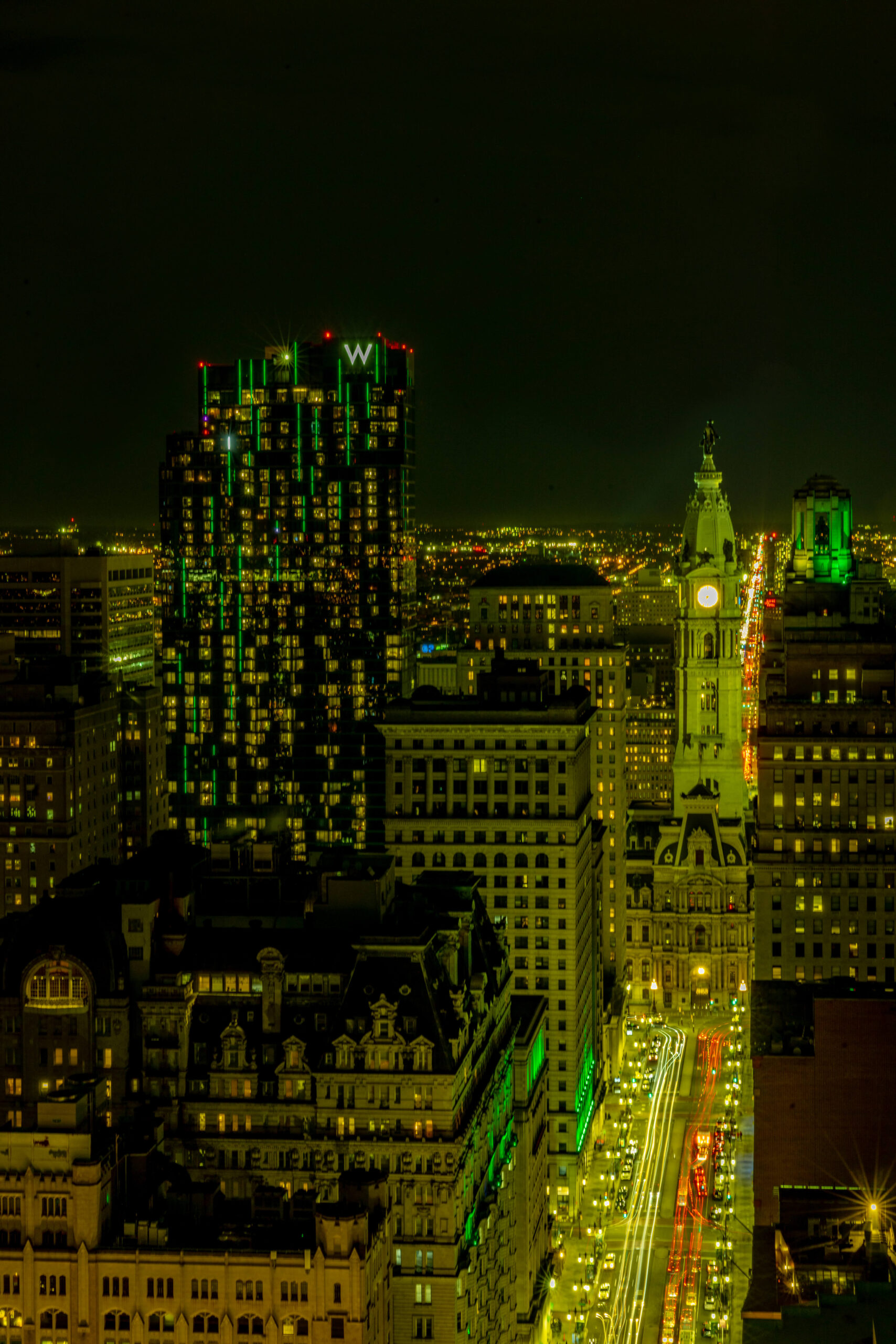 green skyline view of the w philadelphia at night