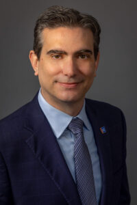 man in blue suit and tie with serious expression