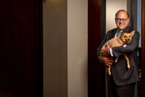 allan domb holding his brown dog at his real estate office in Philadelphia