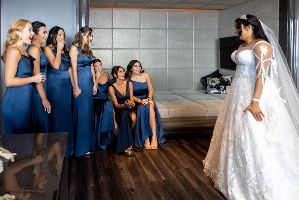 bride reveals wedding dress to bridesmaids in blue dresses at w hotel in philly