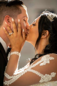 bride and groom kissing and embracing one another during golden hour light