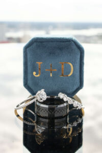 diamond wedding rings and black bands arranged on top of one another