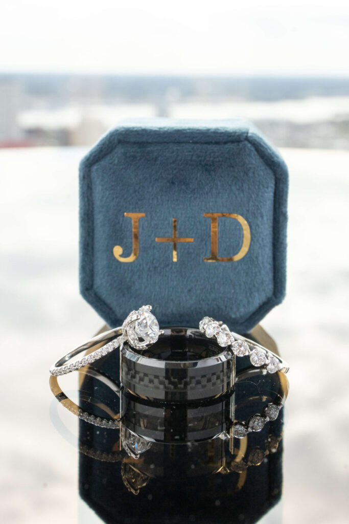 diamond wedding rings and black bands arranged on top of one another