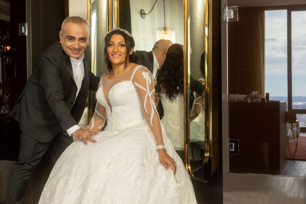 bride in stunning wedding dress poses with designer and stylist