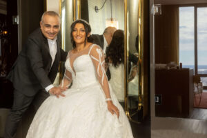 bride in stunning wedding dress poses with designer and stylist