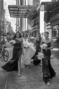 bride walking in front of w hotel with bridesmaids on philly streets